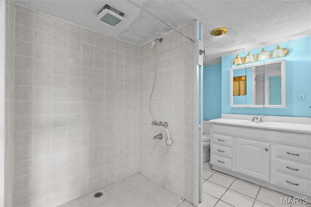 953 E 1st St, Washington, MO 63090 - bathroom with a tile shower, tile patterned floors, vanity, a textured ceiling, and toilet