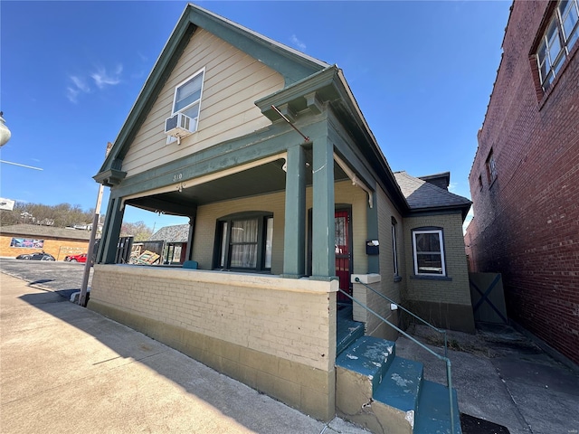 310 N 3rd, Hannibal, MO 63401 - shotgun-style home featuring brick siding, a porch, and cooling unit
