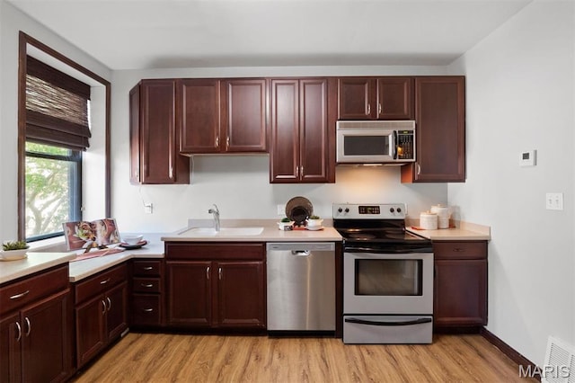 4525 Oakland Ave, Saint Louis, MO 63110 - kitchen featuring stainless steel appliances, a sink, light wood-type flooring, and light countertops