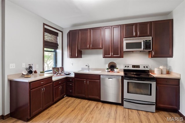 4525 Oakland Ave, Saint Louis, MO 63110 - kitchen with stainless steel appliances, a sink, light countertops, and light wood-style floors