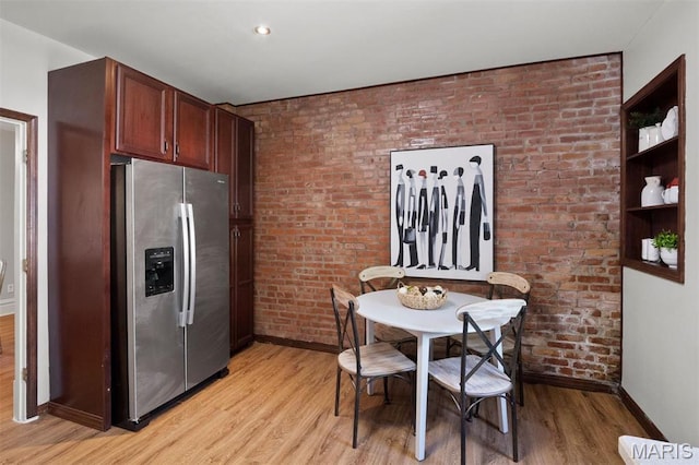 4525 Oakland Ave, Saint Louis, MO 63110 - dining space featuring baseboards, light wood-style flooring, and brick wall
