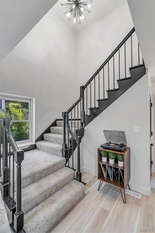 406 Meyer Ave, Saint Louis, MO 63122 - stairway featuring a high ceiling, a chandelier, and wood finished floors
