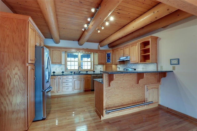 kitchen with stainless steel appliances, a sink, a kitchen breakfast bar, a peninsula, and light wood-type flooring