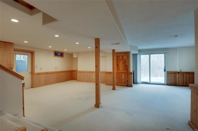basement with wainscoting, carpet floors, recessed lighting, wooden walls, and stairs