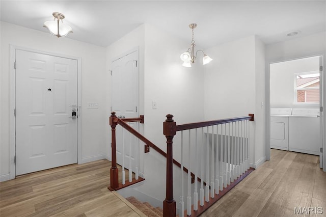entrance foyer featuring washer and dryer, wood finished floors, a chandelier, and baseboards