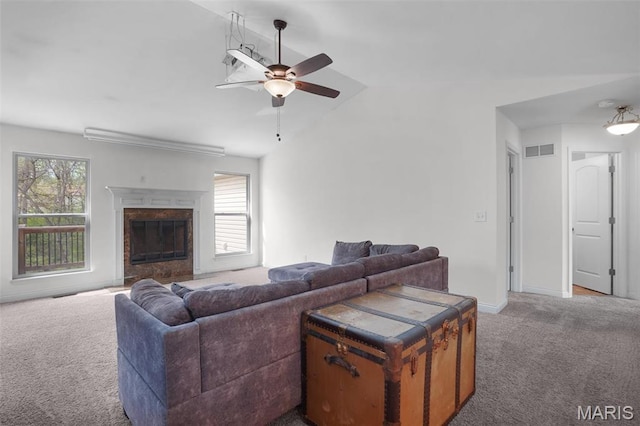 living area with carpet flooring, a ceiling fan, lofted ceiling, a high end fireplace, and baseboards