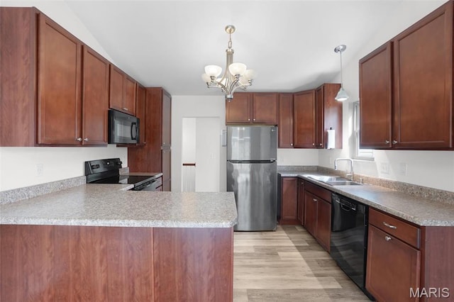 kitchen with black appliances, a sink, a chandelier, a peninsula, and hanging light fixtures