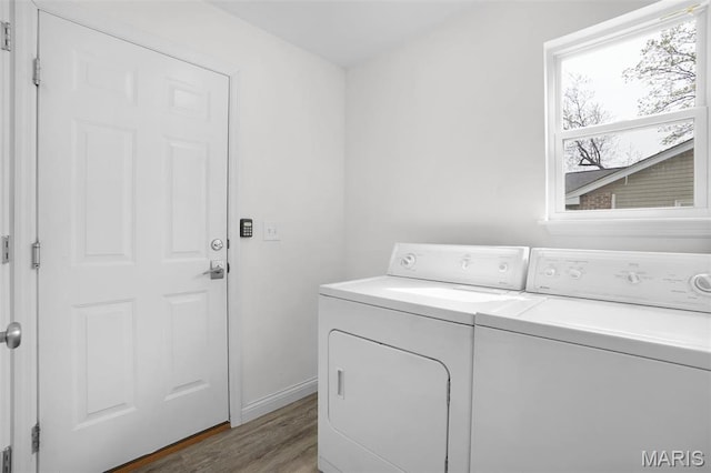 laundry room featuring washing machine and dryer, wood finished floors, and baseboards