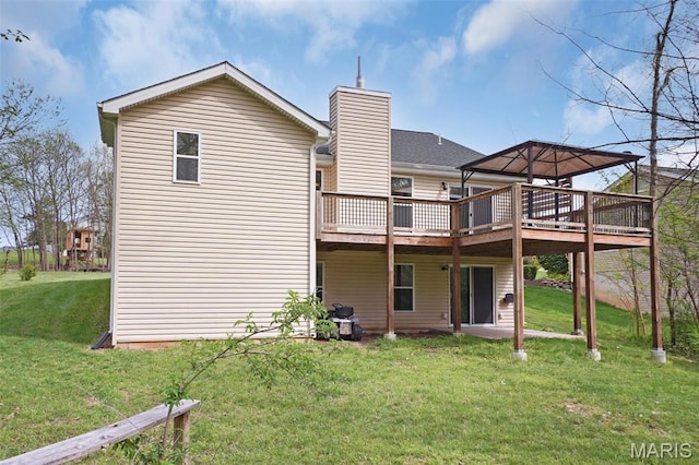rear view of property with a deck, a yard, and a chimney