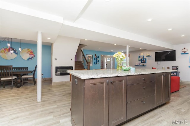 86 Pebblebrook Ln, Saint Louis, MO 63146 - kitchen with light wood finished floors, recessed lighting, dark brown cabinetry, baseboards, and a center island