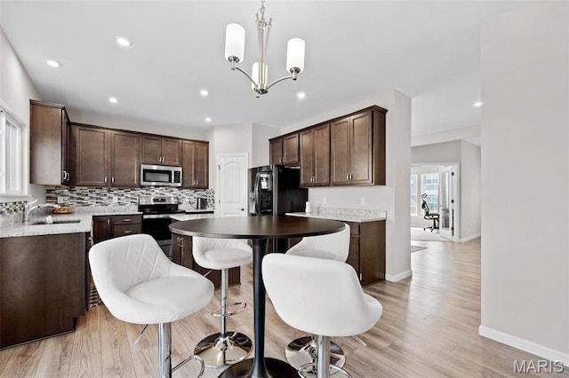 905 Sugar Pear St, Saint Charles, MO 63301 - kitchen with appliances with stainless steel finishes, a sink, dark brown cabinets, tasteful backsplash, and recessed lighting