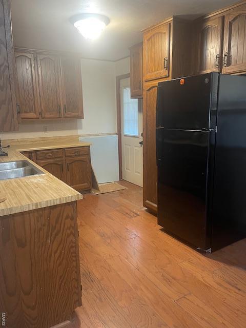 310 Pleasant Ave, Bland, MO 65014 - kitchen with freestanding refrigerator, light wood-style flooring, light countertops, and a sink