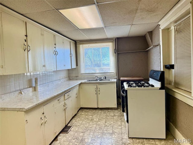 1681 S US Highway 63, West Plains, MO 65775 - kitchen featuring range with gas stovetop, a sink, light countertops, a paneled ceiling, and backsplash