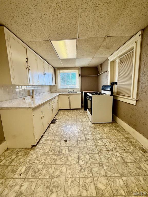 1681 S US Highway 63, West Plains, MO 65775 - kitchen with white gas range, light countertops, a paneled ceiling, white cabinets, and a sink