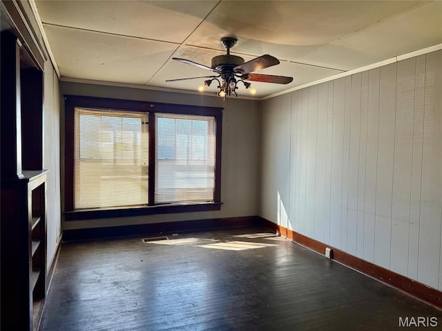 1681 S US Highway 63, West Plains, MO 65775 - spare room featuring ceiling fan, ornamental molding, wooden walls, baseboards, and hardwood / wood-style floors
