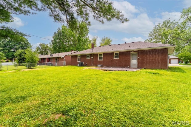304 S Augusta St, Ofallon, IL 62269 - rear view of house featuring a chimney, brick siding, a garage, and central air condition unit