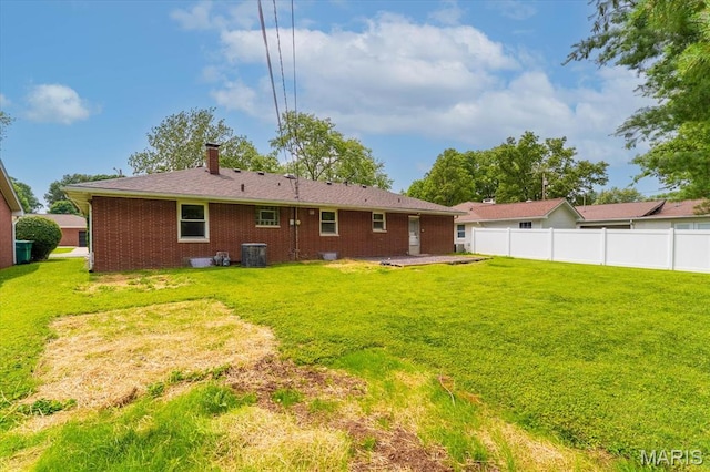 304 S Augusta St, Ofallon, IL 62269 - back of property with central AC unit, brick siding, and a chimney