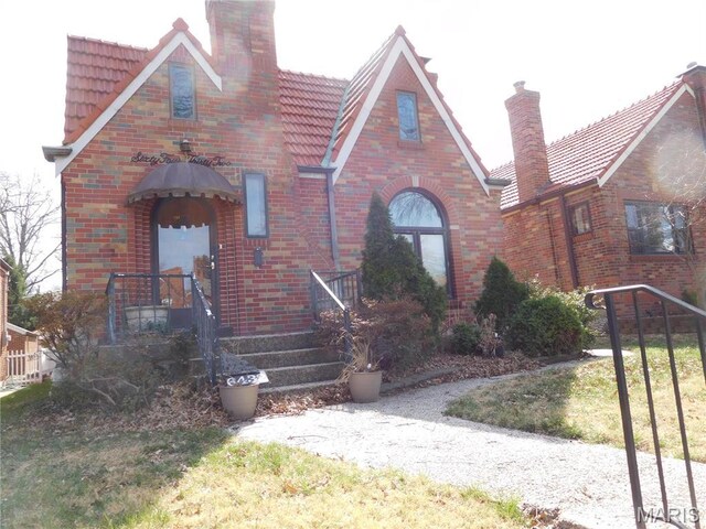 6432 Lansdowne Ave, Saint Louis, MO 63109 - english style home featuring a chimney, a tile roof, and brick siding