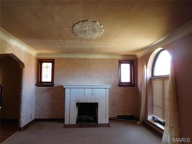 6432 Lansdowne Ave, Saint Louis, MO 63109 - unfurnished living room with a brick fireplace, arched walkways, carpet floors, and crown molding