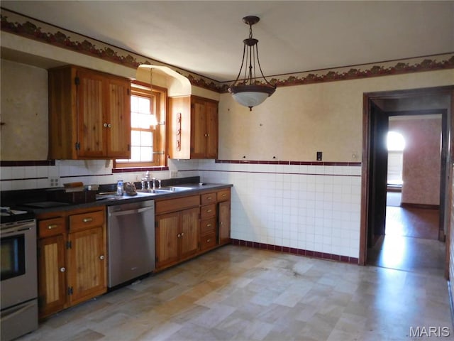 6432 Lansdowne Ave, Saint Louis, MO 63109 - kitchen with appliances with stainless steel finishes, light flooring, brown cabinetry, a sink, and a wainscoted wall