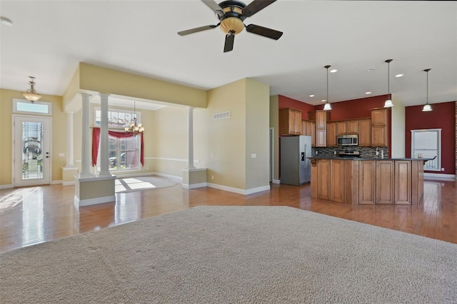 2707 Fairway Estates Dr, Wentzville, MO 63385 - kitchen featuring appliances with stainless steel finishes, decorative columns, open floor plan, dark countertops, and brown cabinets