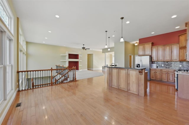 2707 Fairway Estates Dr, Wentzville, MO 63385 - kitchen with stainless steel appliances, light wood-style flooring, a ceiling fan, open floor plan, and tasteful backsplash
