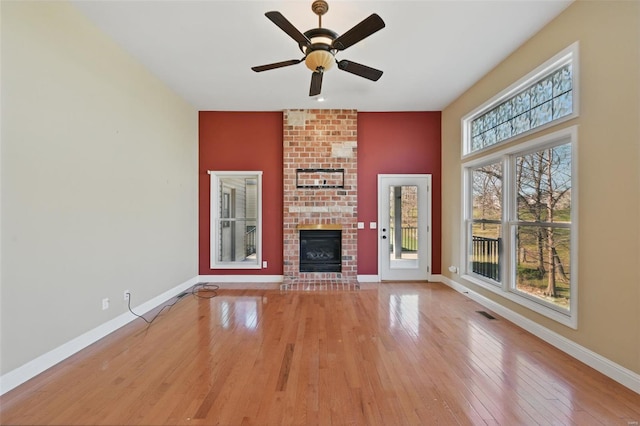 2707 Fairway Estates Dr, Wentzville, MO 63385 - unfurnished living room featuring a brick fireplace, wood-type flooring, baseboards, and ceiling fan