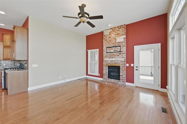 2707 Fairway Estates Dr, Wentzville, MO 63385 - unfurnished living room with light wood finished floors, ceiling fan, a brick fireplace, recessed lighting, and baseboards