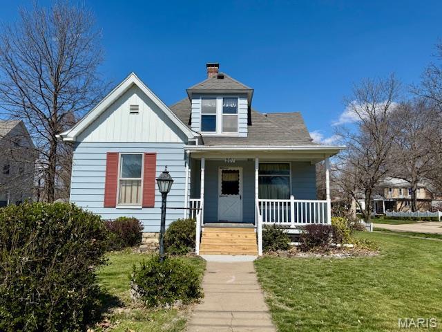 201 W Barr Ave, Jerseyville, IL 62052 - bungalow-style home with covered porch, a front lawn, a chimney, and board and batten siding