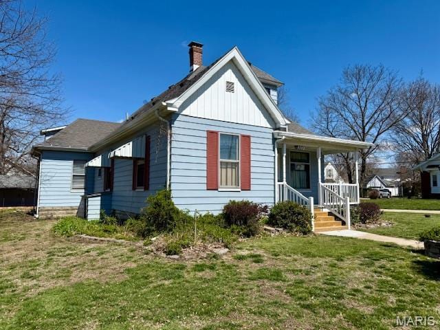 201 W Barr Ave, Jerseyville, IL 62052 - view of front of property featuring board and batten siding, a chimney, a front lawn, and a porch