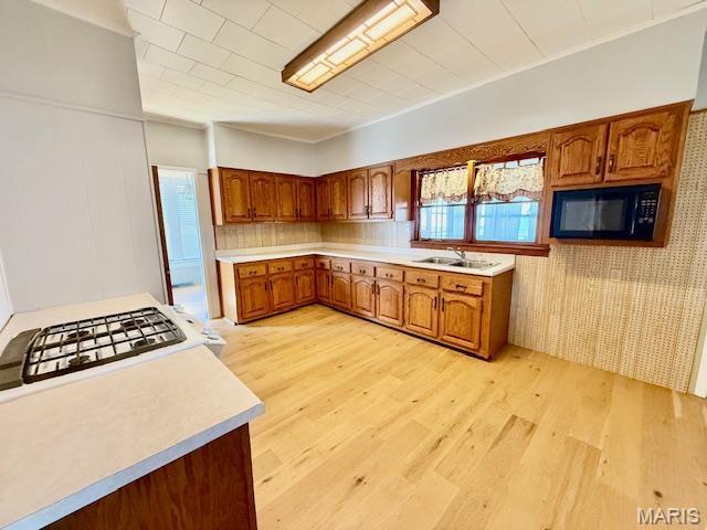 201 W Barr Ave, Jerseyville, IL 62052 - kitchen with black microwave, a sink, light wood finished floors, and brown cabinets