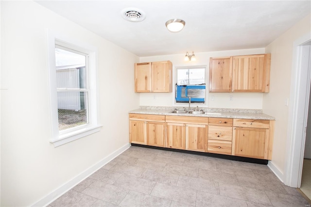 106 N A St, Cuba, MO 65453 - kitchen with light brown cabinetry, a sink, baseboards, and light countertops