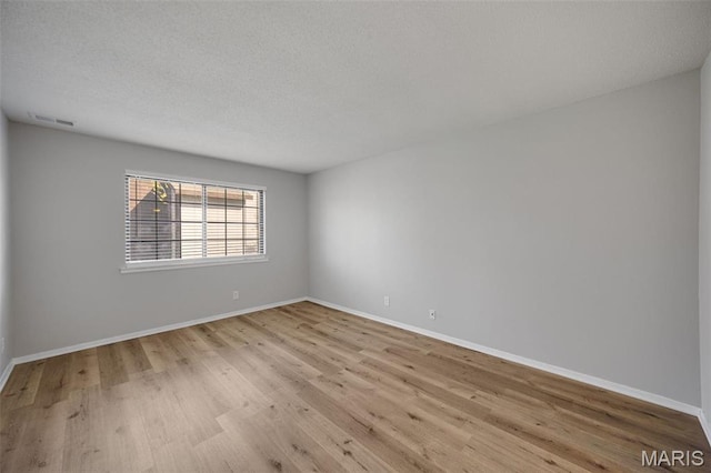 1420 Heritage Lndg Unit 207, Saint Charles, MO 63303 - unfurnished room featuring wood finished floors, baseboards, and a textured ceiling