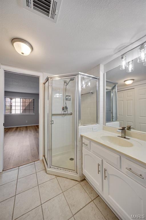 1420 Heritage Lndg Unit 207, Saint Charles, MO 63303 - full bathroom with tile patterned flooring, a shower stall, vanity, and a textured ceiling