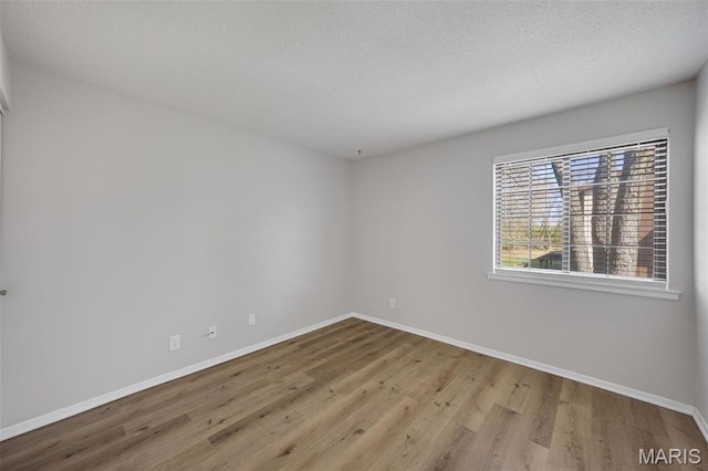 1420 Heritage Lndg Unit 207, Saint Charles, MO 63303 - empty room featuring wood finished floors, baseboards, and a textured ceiling