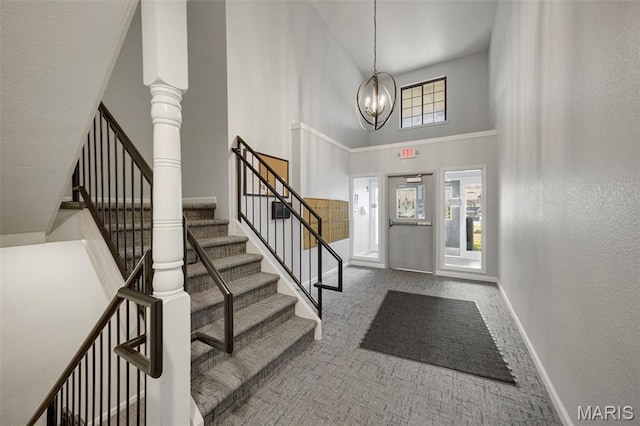 1420 Heritage Lndg Unit 207, Saint Charles, MO 63303 - carpeted entryway featuring a towering ceiling, stairway, a chandelier, baseboards, and a textured wall
