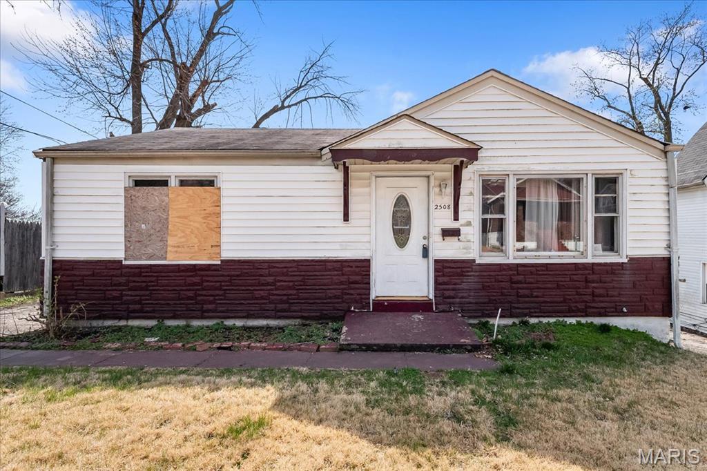 2508 Ada Ave, Saint Louis, MO 63136 - view of front of house with stone siding, a front yard, and roof with shingles