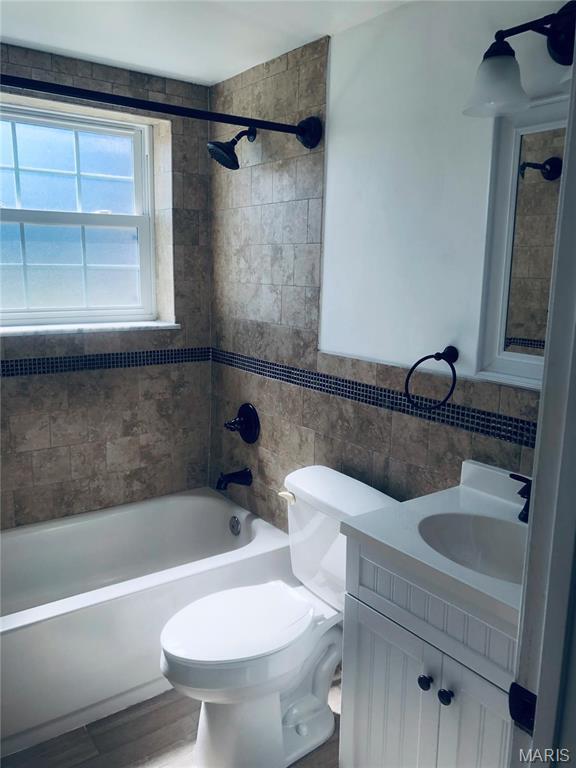 6990 Colonial Woods Dr Unit 59, Saint Louis, MO 63129 - bathroom featuring tile walls, vanity, toilet,  shower combination, and wood finished floors