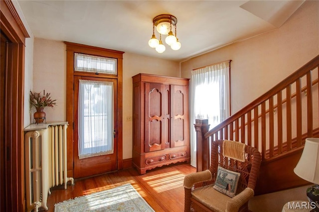 502 N State St, Jerseyville, IL 62052 - entryway with radiator, wood finished floors, a chandelier, baseboards, and stairway