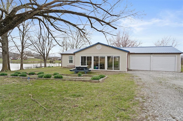 23425 N Everett Carr Rd, Mo, MO 65243 - back of house featuring gravel driveway, a water view, metal roof, a lawn, and an attached garage