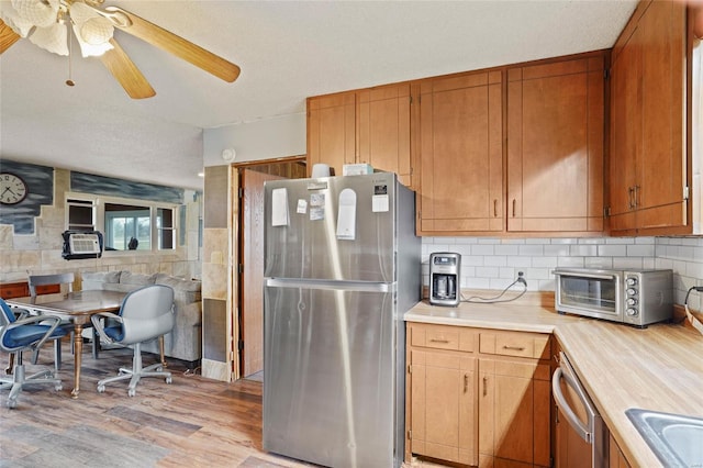 23425 N Everett Carr Rd, Mo, MO 65243 - kitchen with appliances with stainless steel finishes, light wood-type flooring, a ceiling fan, brown cabinets, and a sink