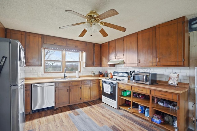 23425 N Everett Carr Rd, Mo, MO 65243 - kitchen with stainless steel appliances, a sink, under cabinet range hood, light wood-style flooring, and a textured ceiling