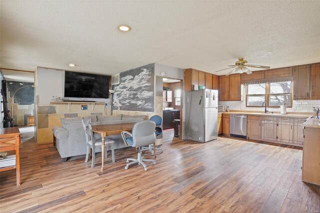 23425 N Everett Carr Rd, Mo, MO 65243 - kitchen with freestanding refrigerator, dishwasher, a textured ceiling, a sink, and light wood-style floors
