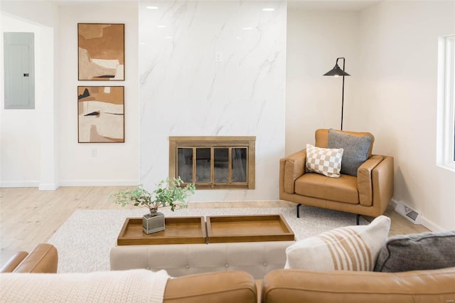 407 Front St, Monroe City, MO 63456 - living room with electric panel, wood finished floors, baseboards, and a premium fireplace
