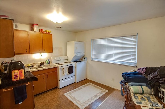 kitchen with white electric range oven, stacked washing machine and dryer, a sink, tasteful backsplash, and light countertops