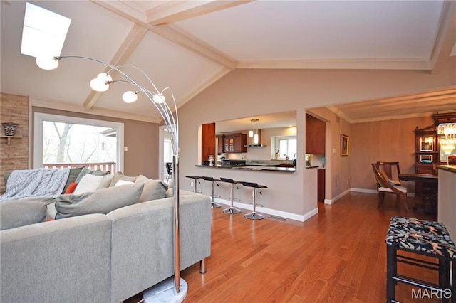 living room with wood finished floors, lofted ceiling, and baseboards