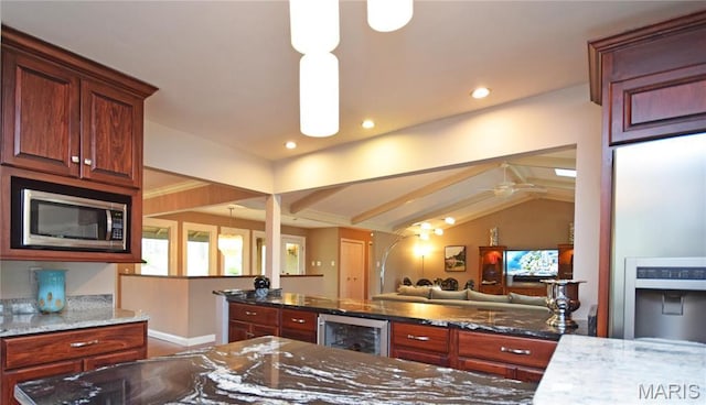 kitchen featuring stainless steel microwave, wine cooler, open floor plan, dark stone counters, and lofted ceiling