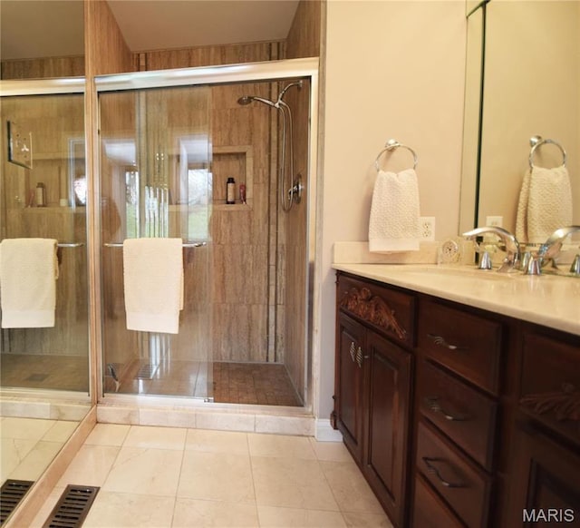 bathroom with a stall shower, vanity, and tile patterned flooring