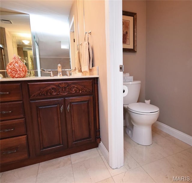 bathroom with baseboards, toilet, vanity, and marble finish floors
