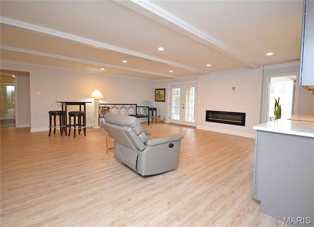 living room featuring beamed ceiling, healthy amount of natural light, light wood-style floors, baseboards, and recessed lighting
